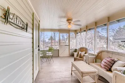 a screened in porch with a couch and chairs at Colorado Chautauqua Cottages in Boulder