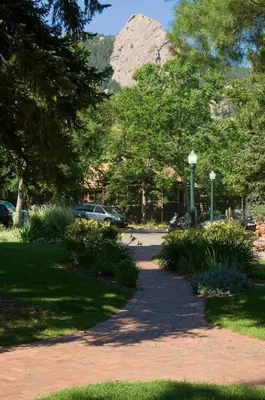 a walkway in a park with a mountain in the background at Colorado Chautauqua Cottages in Boulder