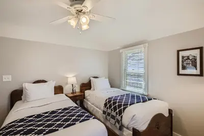 a bedroom with two beds and a ceiling fan at Colorado Chautauqua Cottages in Boulder