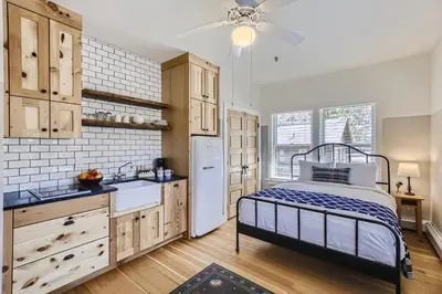 a kitchen with a bed and a white refrigerator at Colorado Chautauqua Cottages in Boulder