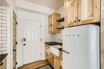 a kitchen with wooden cabinets and a refrigerator at Colorado Chautauqua Cottages in Boulder