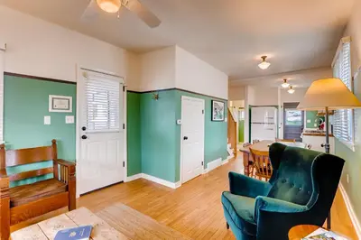 a living room with a blue chair and a table at Colorado Chautauqua Cottages in Boulder