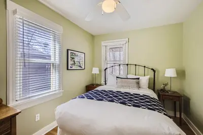 a bedroom with a bed and two windows at Colorado Chautauqua Cottages in Boulder