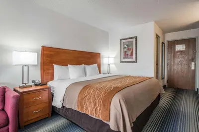 a hotel room with a bed and a chair at Quality Inn Denver Westminster in Westminster