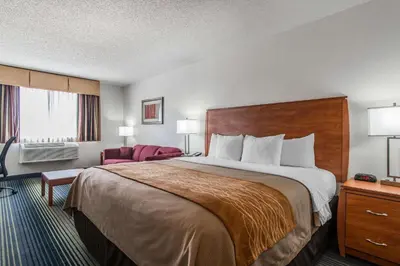 a hotel room with a large bed and a chair at Quality Inn Denver Westminster in Westminster