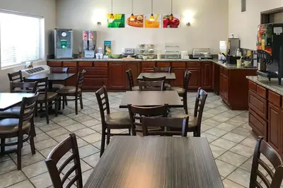 a restaurant with tables and chairs and a kitchen at Quality Inn Denver Westminster in Westminster