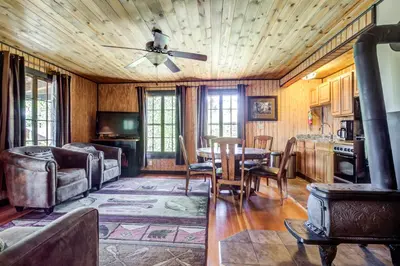 a living room with a table and a ceiling fan at Grand Lake Lodge in Grand Lake