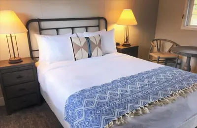 a bedroom with a large white bed with two lamps at Grand Lake Lodge in Grand Lake