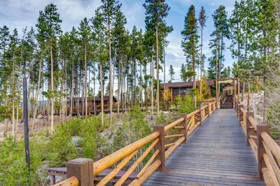 a wooden boardwalk leading to a house in the woods at Grand Lake Lodge in Grand Lake