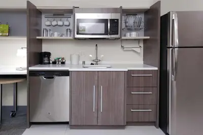 a kitchen with a sink and a stainless steel refrigerator at Home2 Suites By Hilton Fort Collins in Fort Collins