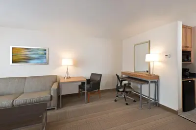 a hotel room with a couch and a desk and a table at Holiday Inn Express Hotel & Suites Fraser Winter Park Area by IHG in Fraser