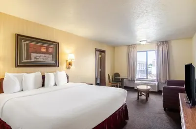 a hotel room with a large bed and a television at Americas Best Value Inn & Suites Ft Collins E at I-25 in Fort Collins