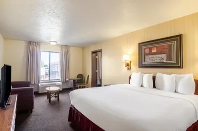 a hotel room with a large bed and a television at Americas Best Value Inn & Suites Ft Collins E at I-25 in Fort Collins