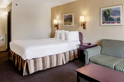 a hotel room with a large bed and a couch at Americas Best Value Inn & Suites Ft Collins E at I-25 in Fort Collins