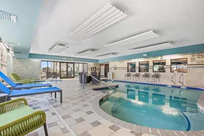 a pool in a hotel room with chairs and tables at Hampton Inn & Suites Greeley in Greeley