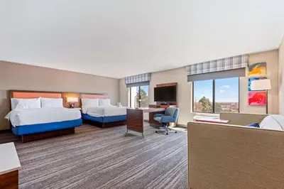 a hotel room with two beds and a desk at Hampton Inn & Suites Greeley in Greeley