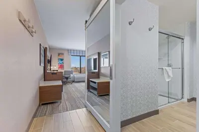 a bathroom with a glass door leading into a room at Hampton Inn & Suites Greeley in Greeley
