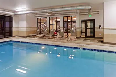 a large swimming pool with chairs at Hampton Inn & Suites Denver Airport / Gateway Park in Denver