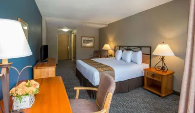 a hotel room with a bed and a table at Winter Park Mountain Lodge in Winter Park