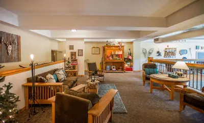 a large living room with a christmas tree in it at Winter Park Mountain Lodge in Winter Park
