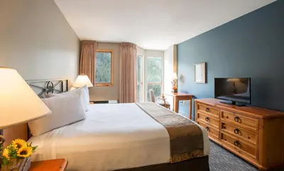 a hotel room with a bed and a television at Winter Park Mountain Lodge in Winter Park