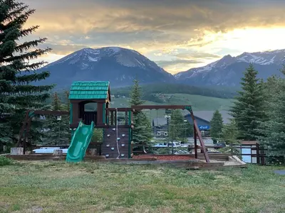 a playground with a slide in front of a mountain at Dillon Inn in Dillon