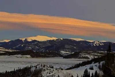 a snow covered mountain range with snow covered mountains at Dillon Inn in Dillon