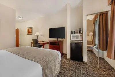 a hotel room with a bed and a flat screen tv at Best Western Plus Boulder Louisville in Louisville