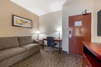 a hotel room with a couch and a desk and a table at Best Western Plus Boulder Louisville in Louisville