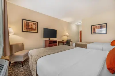 a hotel room with two beds and a tv at Best Western Plus Boulder Louisville in Louisville