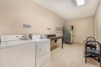 a kitchen with a refrigerator and a table and a chair at Best Western Plus Boulder Louisville in Louisville