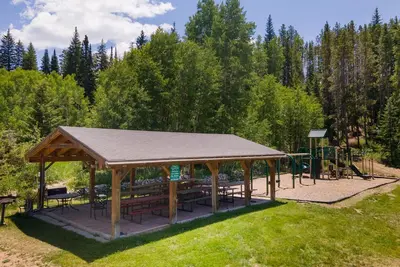 a pavilion with tables and benches in a park at Hi Country Haus Unit 1515 in Winter Park