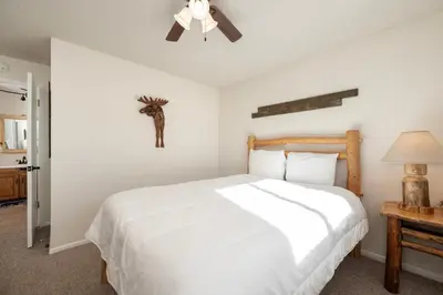 a bedroom with a white bed and a ceiling fan at Hi Country Haus Unit 1515 in Winter Park