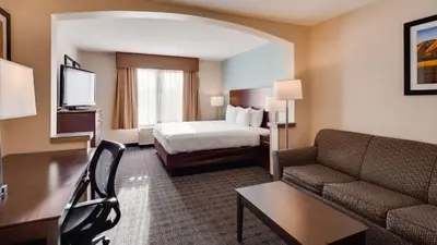 a hotel room with a bed and a couch at Best Western Plus Gateway Inn & Suites - Aurora in Aurora