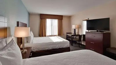 a hotel room with two beds and a flat screen tv at Best Western Plus Gateway Inn & Suites - Aurora in Aurora