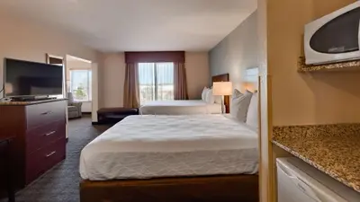 a hotel room with two beds and a flat screen tv at Best Western Plus Gateway Inn & Suites - Aurora in Aurora