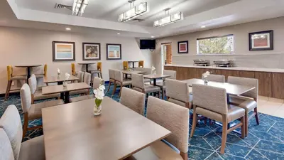 a restaurant with tables and chairs and a bar at Best Western Plus Gateway Inn & Suites - Aurora in Aurora