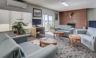 a living room with two couches and a tv at Americas Best Value Inn Greeley in Evans