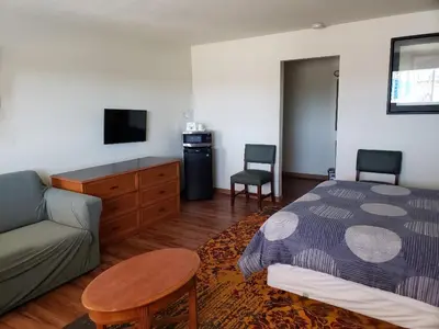 a living room with a bed and a couch at Americas Best Value Inn Greeley in Evans