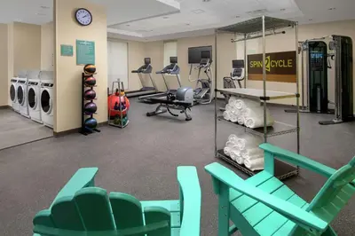 a gym with green chairs and exercise equipment at Home2 Suites By Hilton Longmont in Longmont