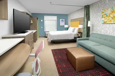 a hotel room with a couch and a bed at Home2 Suites By Hilton Longmont in Longmont