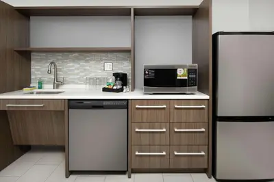 a kitchen with a refrigerator and a microwave at Home2 Suites By Hilton Longmont in Longmont