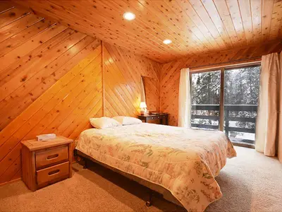 a bedroom with a bed and a large window at 61 Jabberwocky Home by Stay Winter Park in Fraser