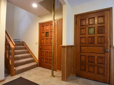 a hallway with a wooden door and stairs with a staircase at 61 Jabberwocky Home by Stay Winter Park in Fraser
