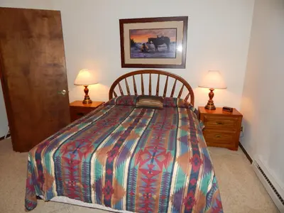 a bedroom with a bed with two night stands and two lamps at Timber Ridge Building B, Unit 2 in Winter Park