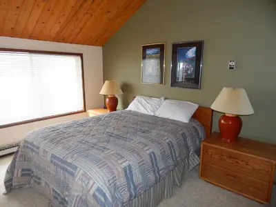 a bedroom with a bed and two lamps and a window at Timber Ridge Building B, Unit 2 in Winter Park