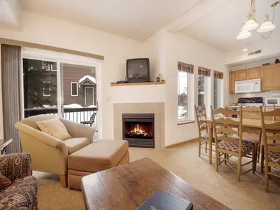 a living room with a fireplace and a table at Winterstar Building G #3 by Stay Winter Park in Fraser