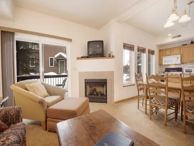 a living room with a fireplace and a table at Winterstar Building G #3 by Stay Winter Park in Fraser