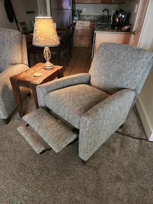 a living room with a chair and a lamp on a table at Heart of Frisco Condo in Frisco
