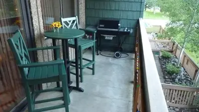 a patio with a table and chairs on a porch at Heart of Frisco Condo in Frisco